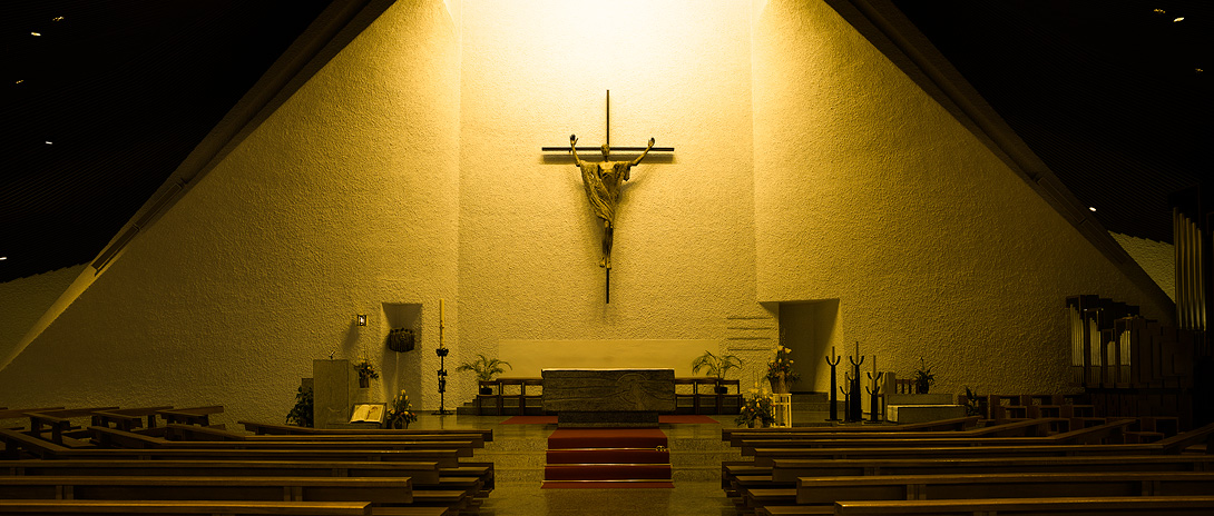 Bild der Kirchenbänke mit Blick zum Altar