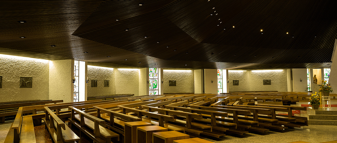 Bild der Kirchenbänke mit Blick zu den Kirchenfenstern